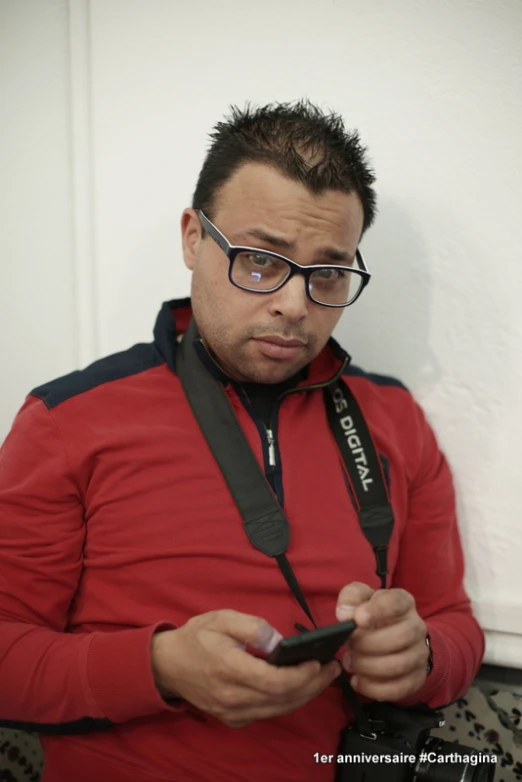 a man with glasses using his cell phone