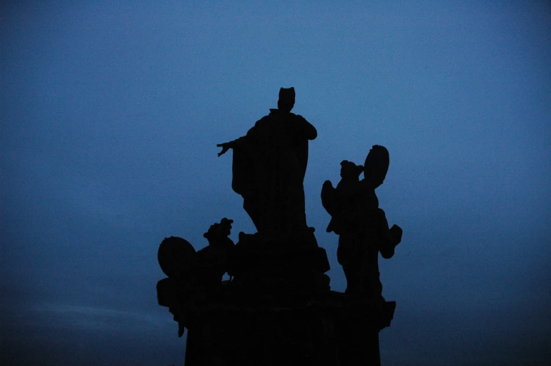 a bird sitting on top of the side of a statue