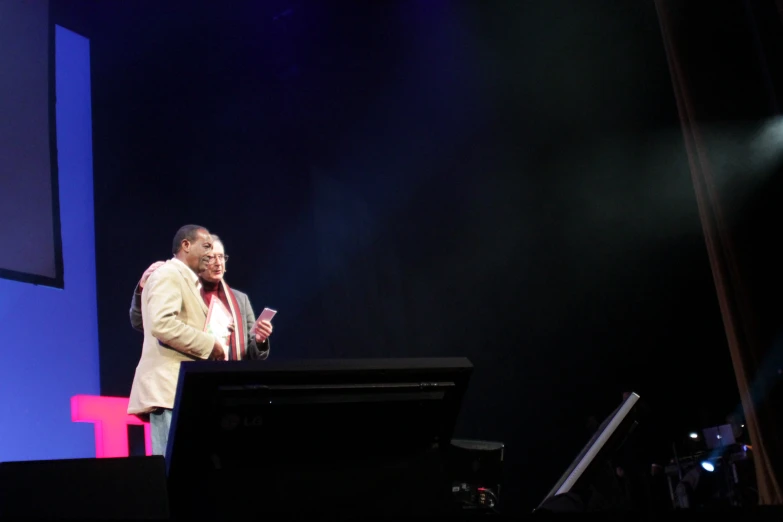 man standing at podium on stage during a performance