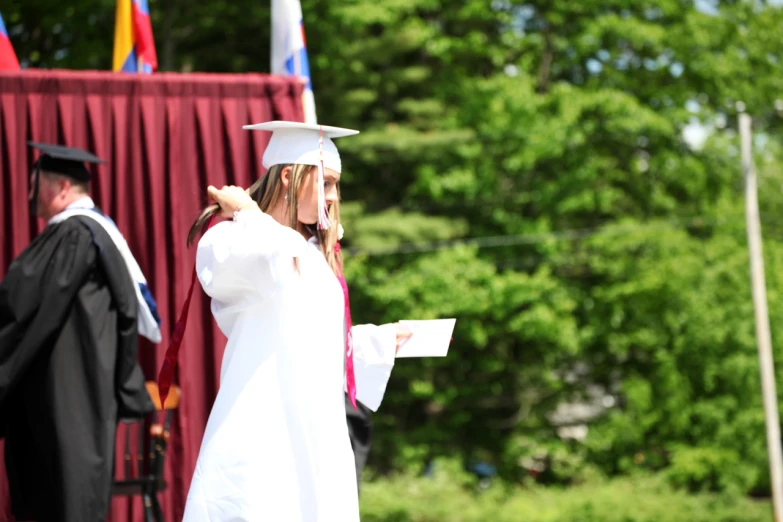 a person in graduation clothes standing at the end of a stage