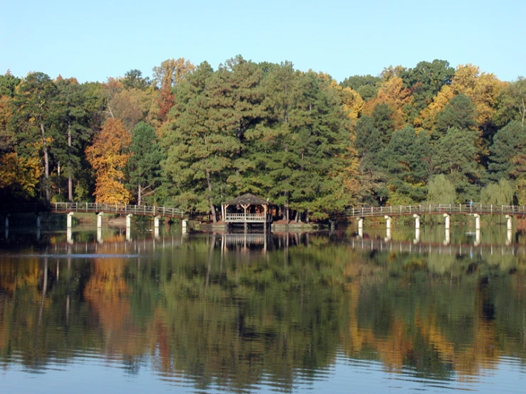 a small dock is surrounded by the water and trees