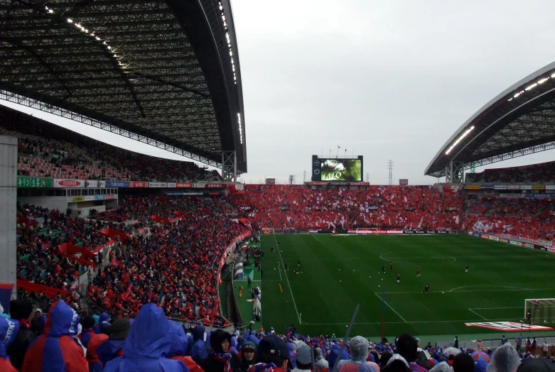 some fans are watching some soccer match in the stadium