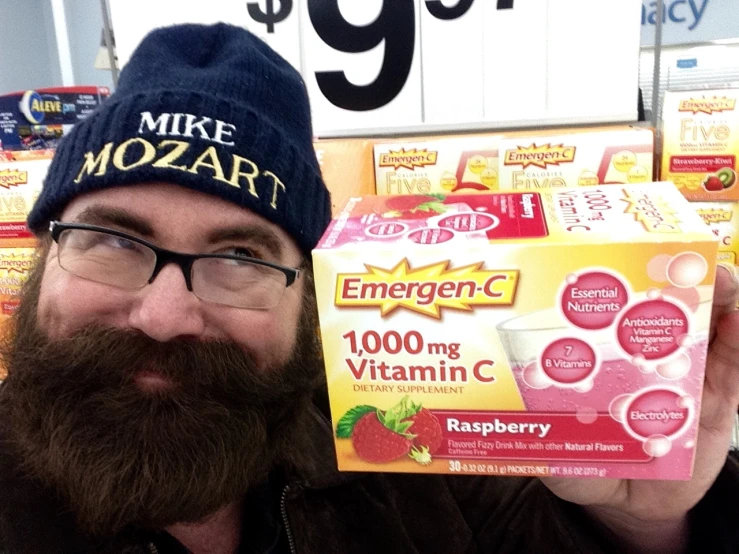 a man holding up a carton of pills