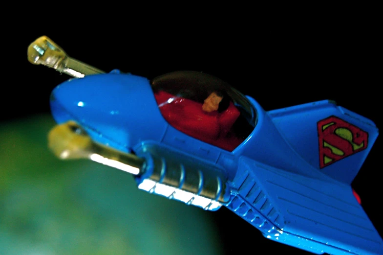 a toy man riding in the inside of a blue plastic jet