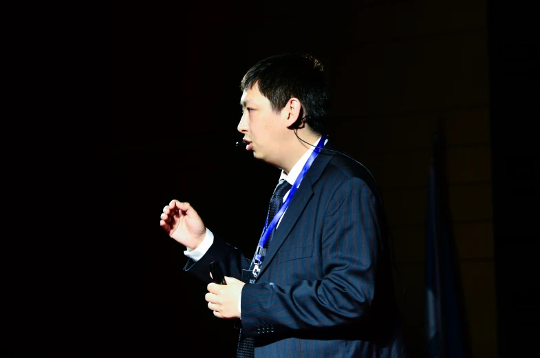 a man standing and wearing a blue suit and tie