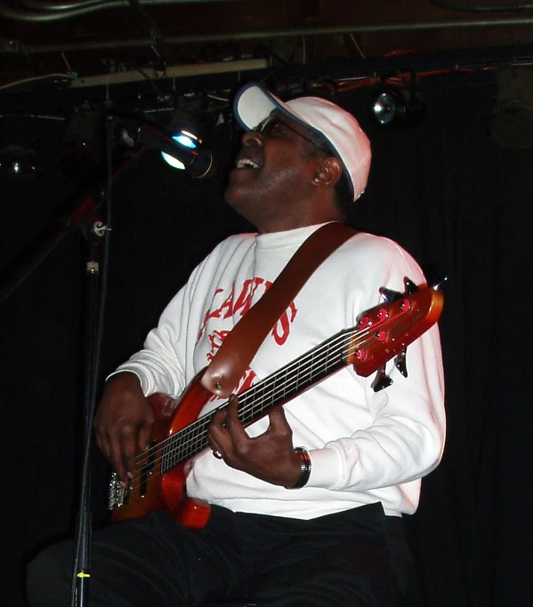 a man in white is playing the bass