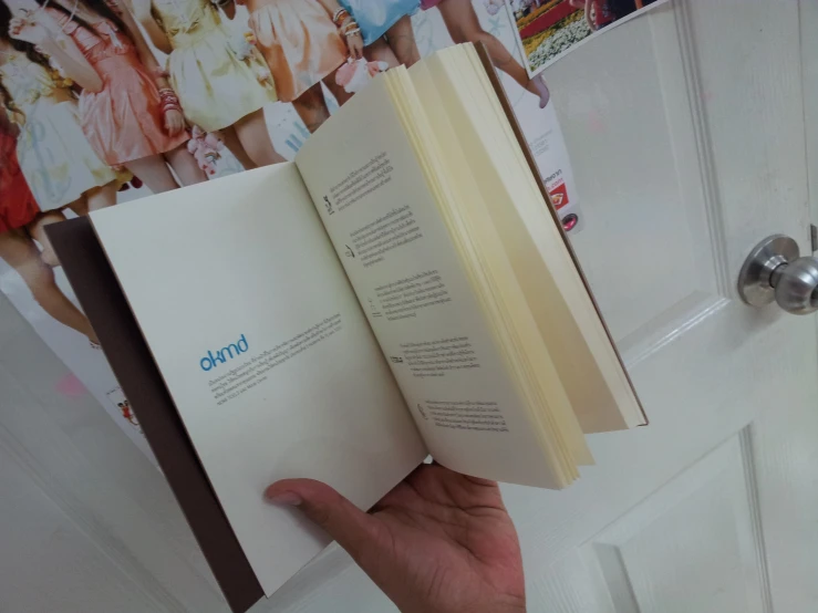 a person holding a book above their head in front of a door