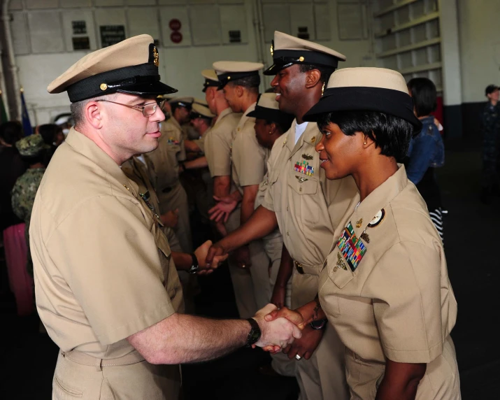 some uniformed people and some are shaking hands