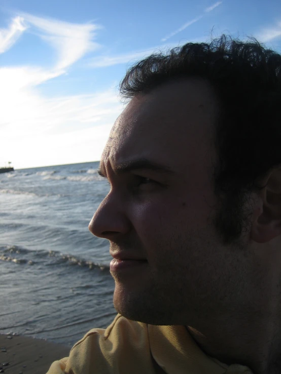 the man smiles for the camera while at the beach