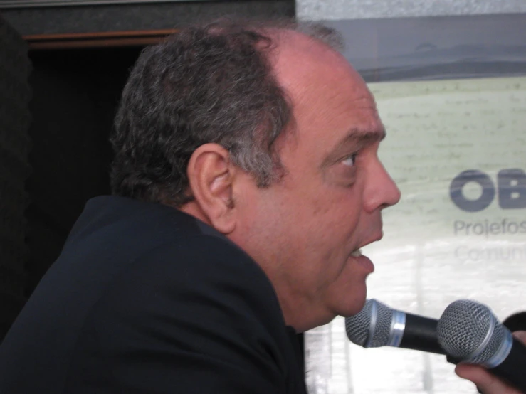 a man in black jacket holding a microphone