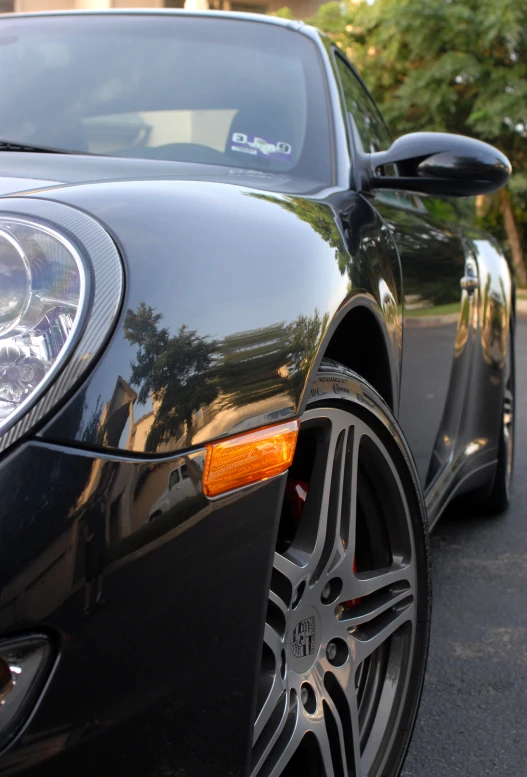 the side of a black sports car with chrome rims