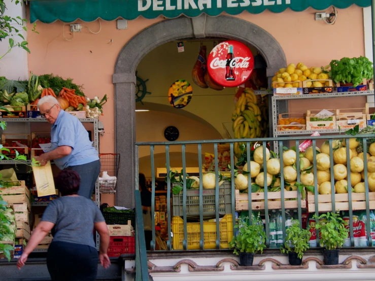 people walking out a food store next to an entrance