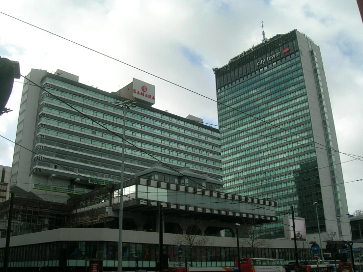 two very tall buildings stand against a cloudy sky