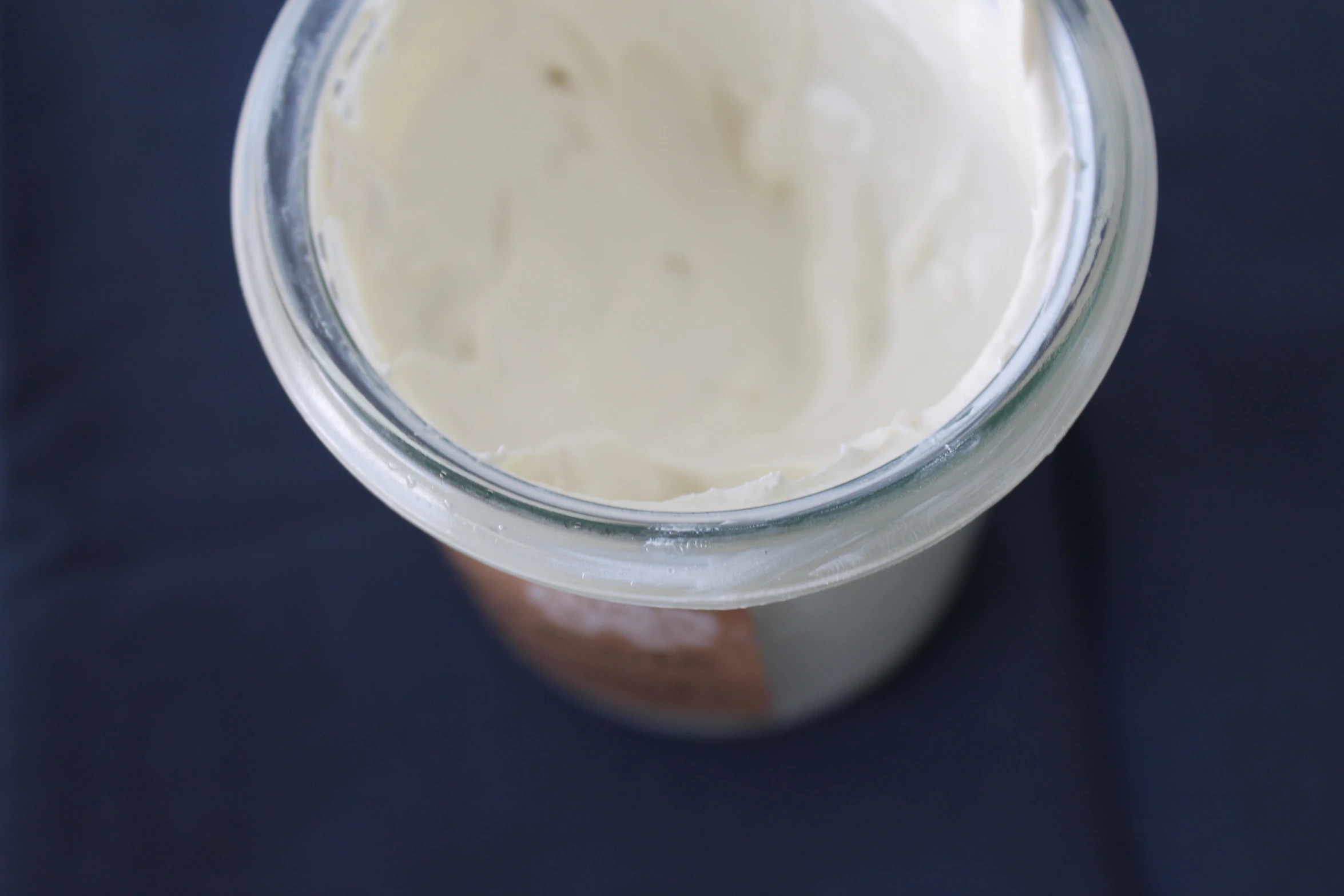 a jar filled with white liquid sitting on a blue table cloth