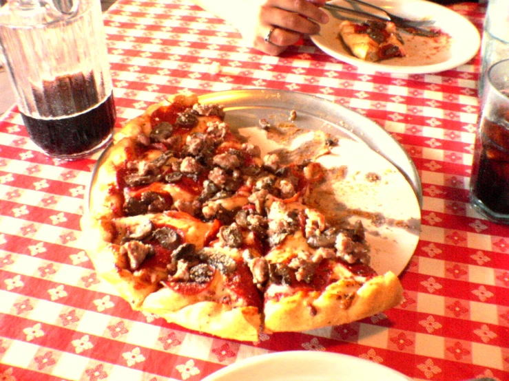 a table covered in a plate of pizza and glasses