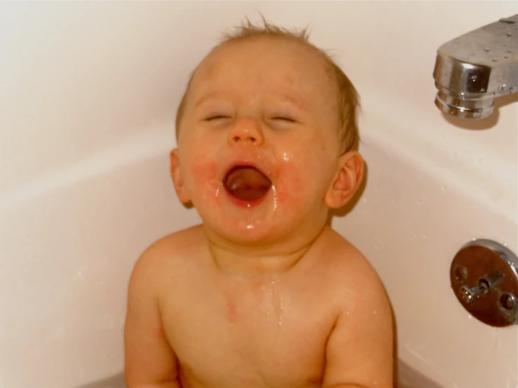 a baby is crying in the bathtub