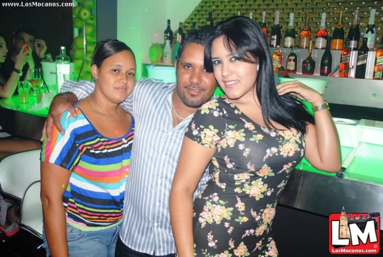 a man and woman posing for a picture in front of bottles