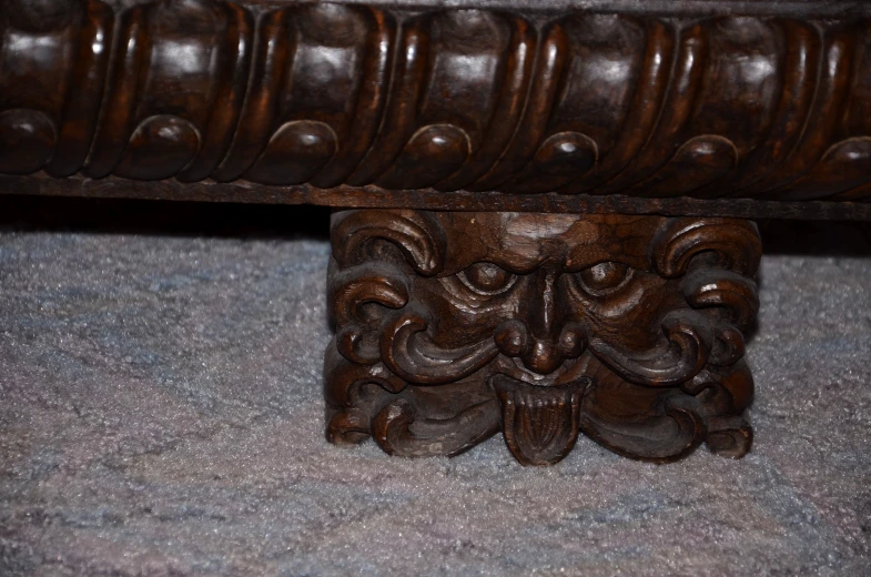 a very large ornate wooden bench that is on carpet