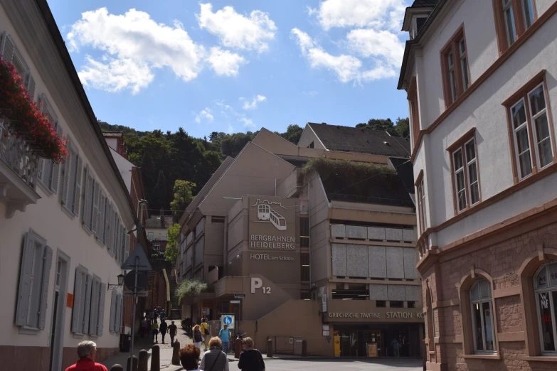 a group of people walking down a walkway between buildings