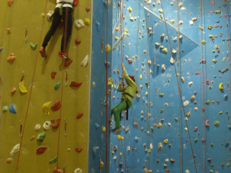 a close up of two people climbing on a wall