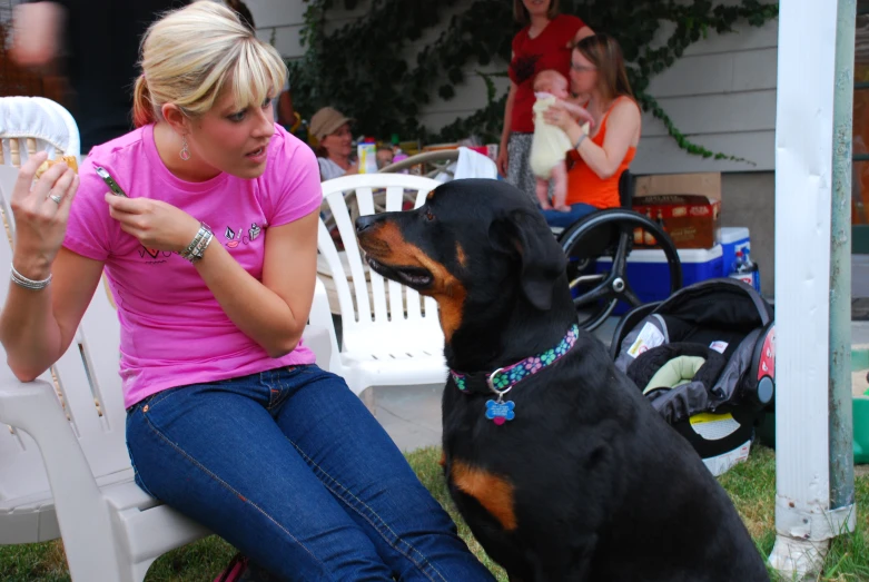 a woman kneeling down while petting a dog