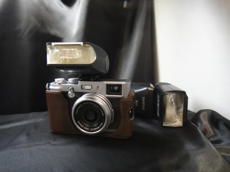 an old camera sitting on top of a black cloth