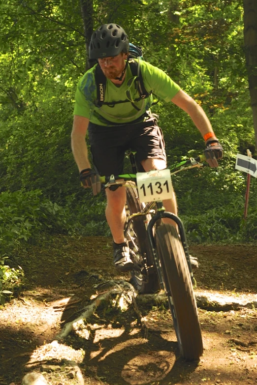 the man is riding his bicycle through the woods