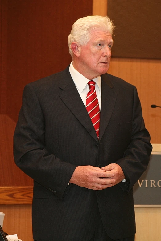 a man in a suit and tie speaking at a podium