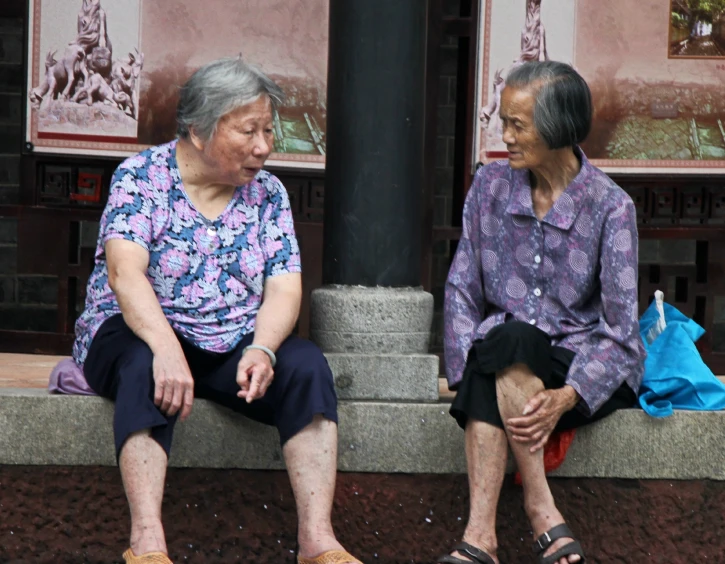 the asian people sit side by side while outside