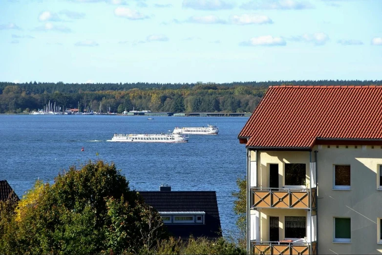 a boat going past a large white house