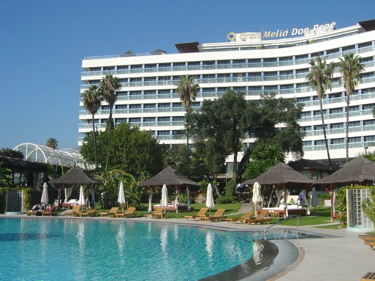 a el building in the distance behind an outdoor swimming pool