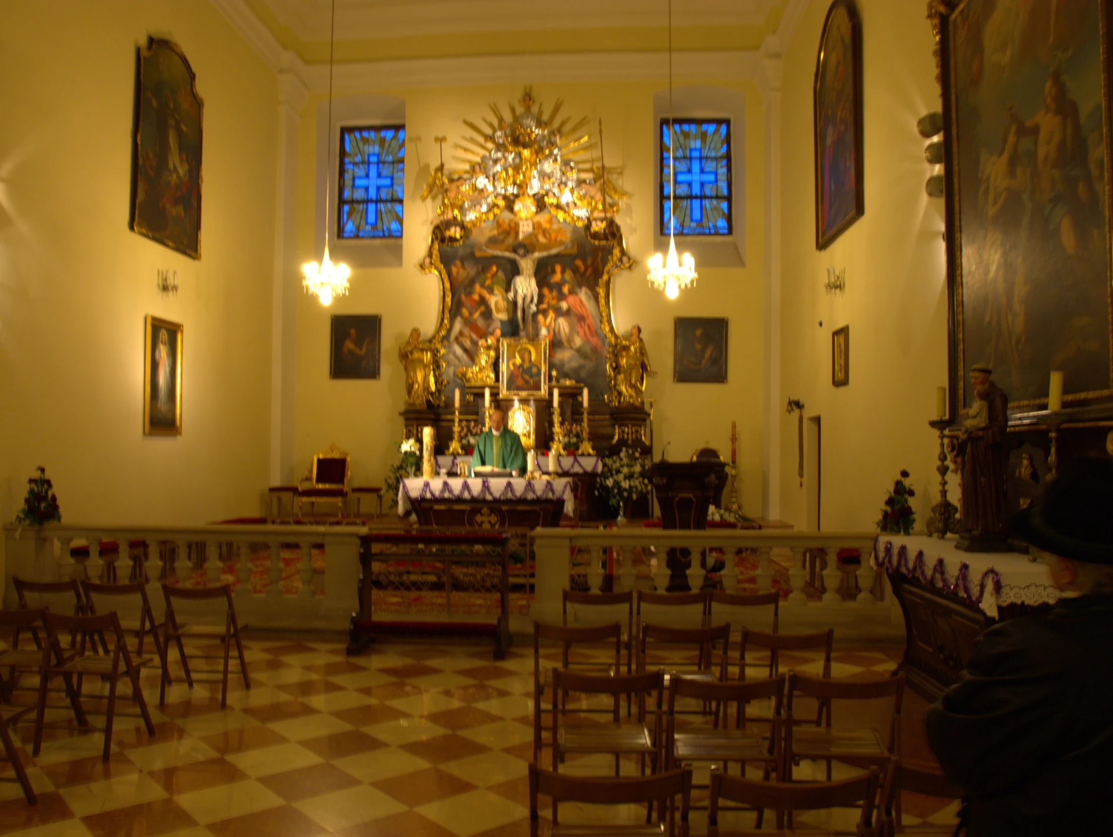 an altar with many chairs, and the back wall is painted yellow