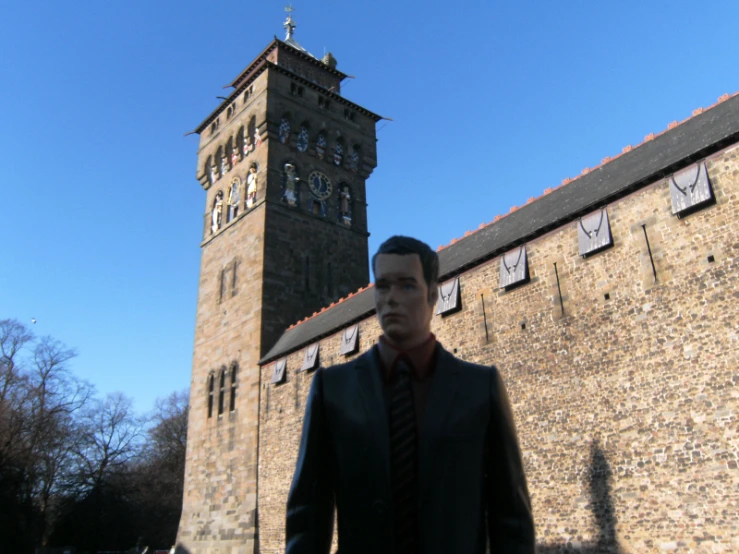 a man in a suit and tie standing next to a tall tower