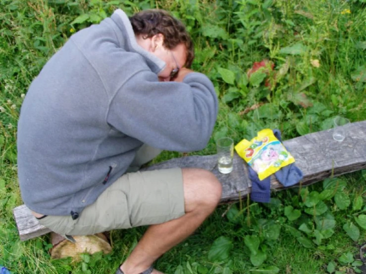 a man leaning on a post in the grass