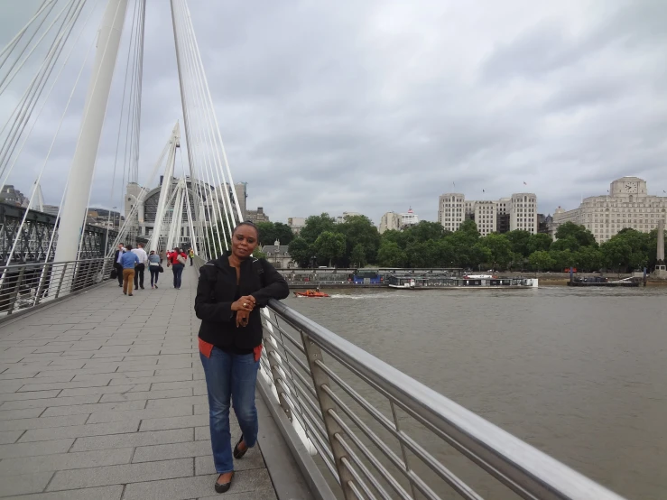 a man standing on top of a bridge near a river