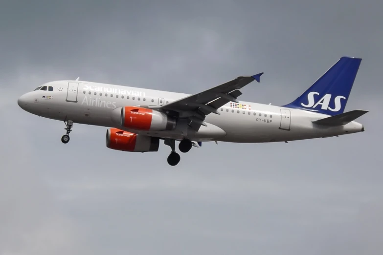 an airplane flying in the sky with its landing gear down