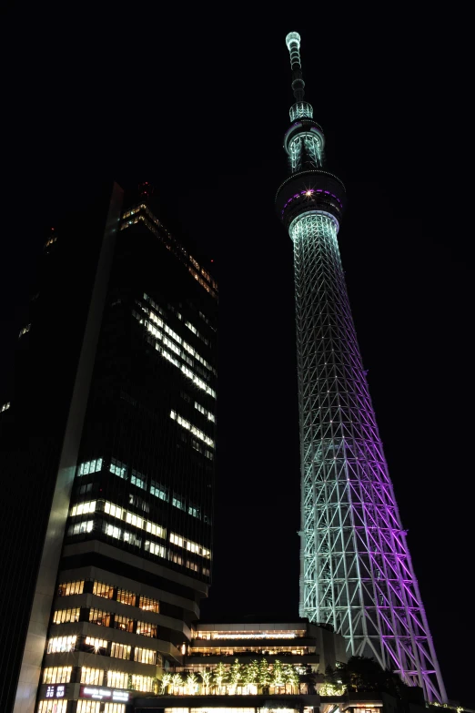 a building with lights on near two large buildings