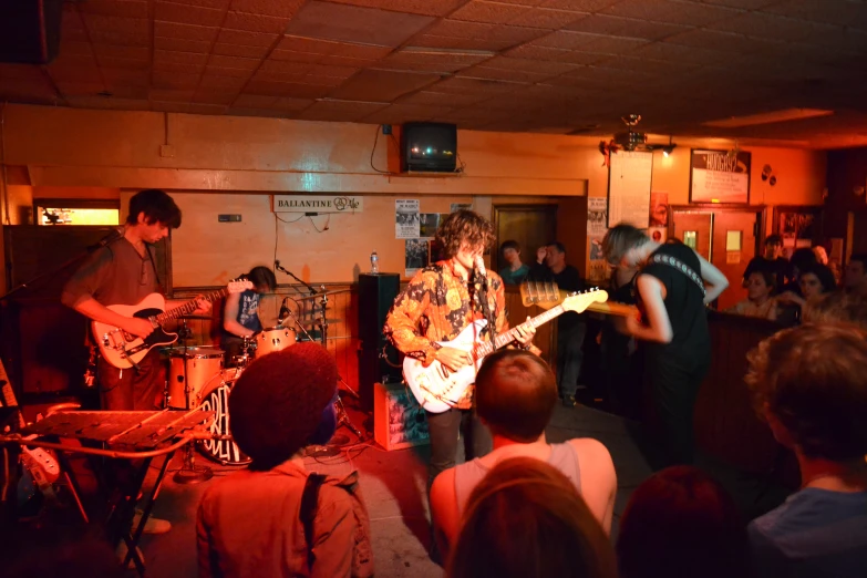 band playing in small room with many people