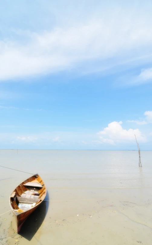 an empty boat sits on the shore