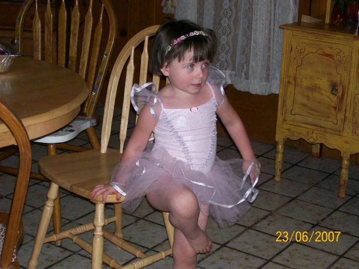 a  dressed in pink posing in a princess dress