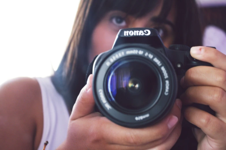 a woman holding a camera up to the camera