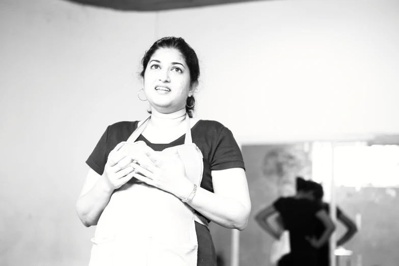 black and white pograph of a woman wearing a apron