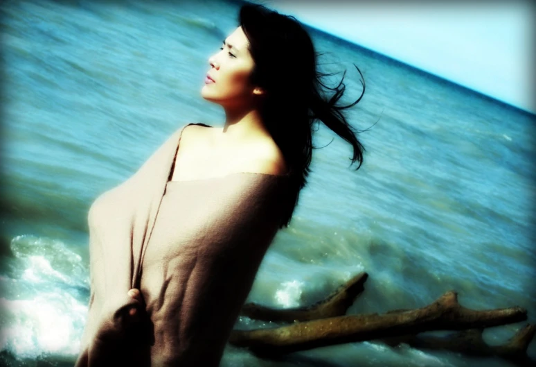 a beautiful young lady walking along the ocean