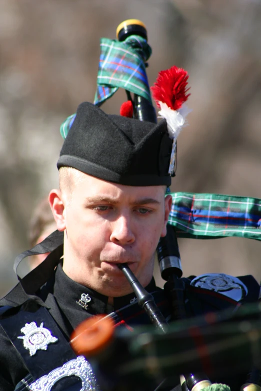 the young man is playing the bagpipe while dressed in kilt