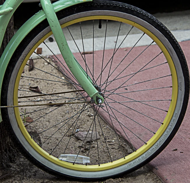 a close up of the spokes of a green bicycle
