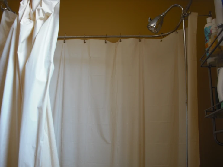 a shower curtain hanging up in front of a toilet and shower head