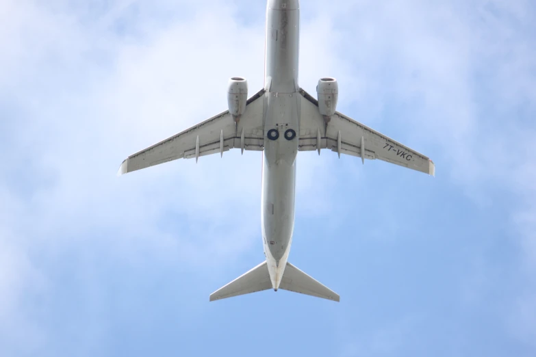 a passenger jet flies in the sky with its landing gear down