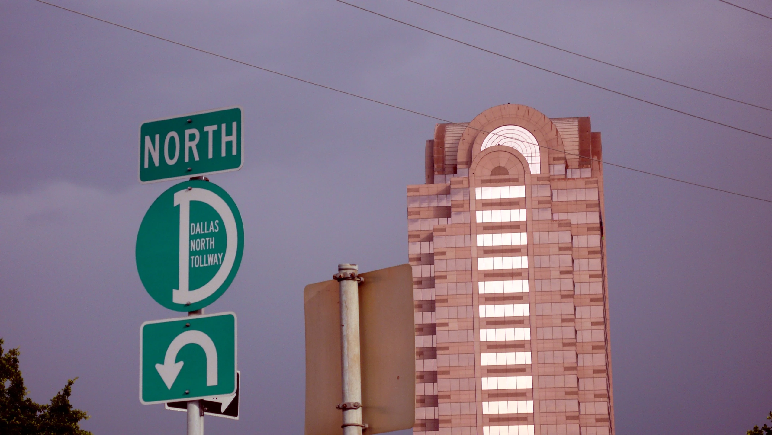 a very tall tower behind several traffic signs