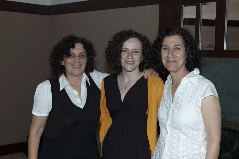 three woman standing next to each other in front of a window