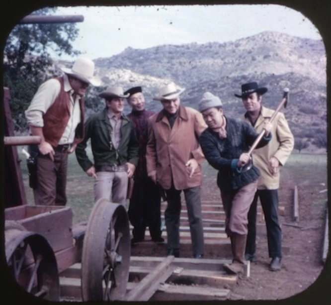 some men that are standing together by some fence